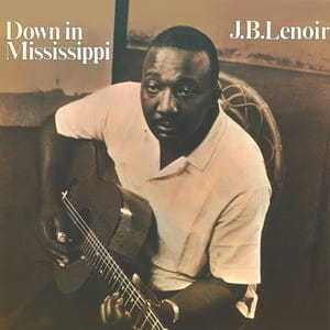 JB Lenoir sitting in a chair with a guitar